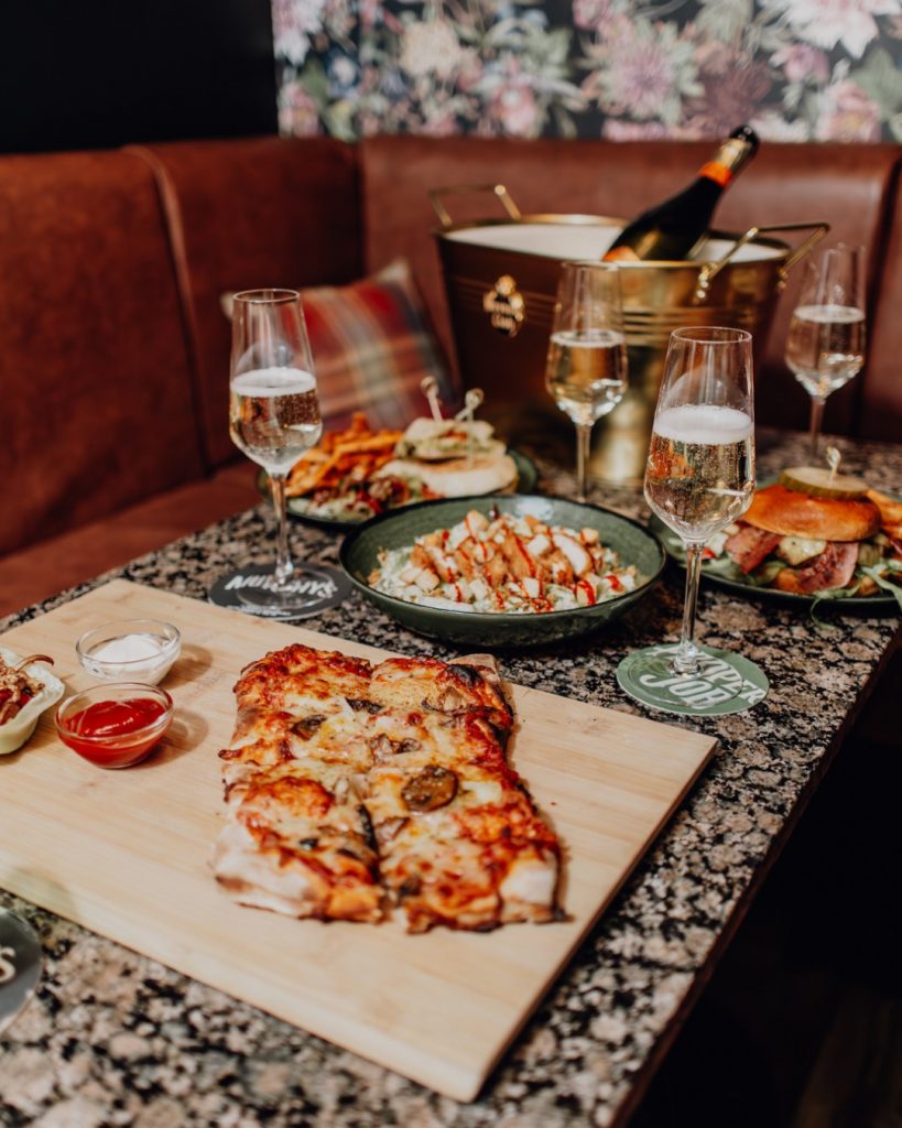 A table of pizza, sides and drinks at Oriels Exeter