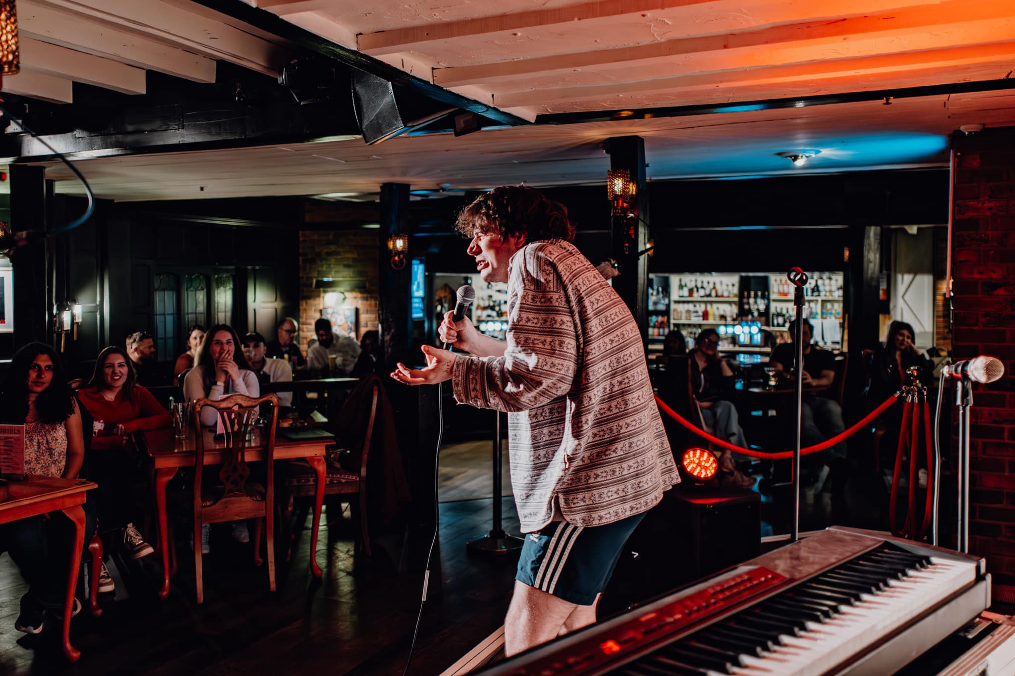 Comedian performing in front of the Oriels audience