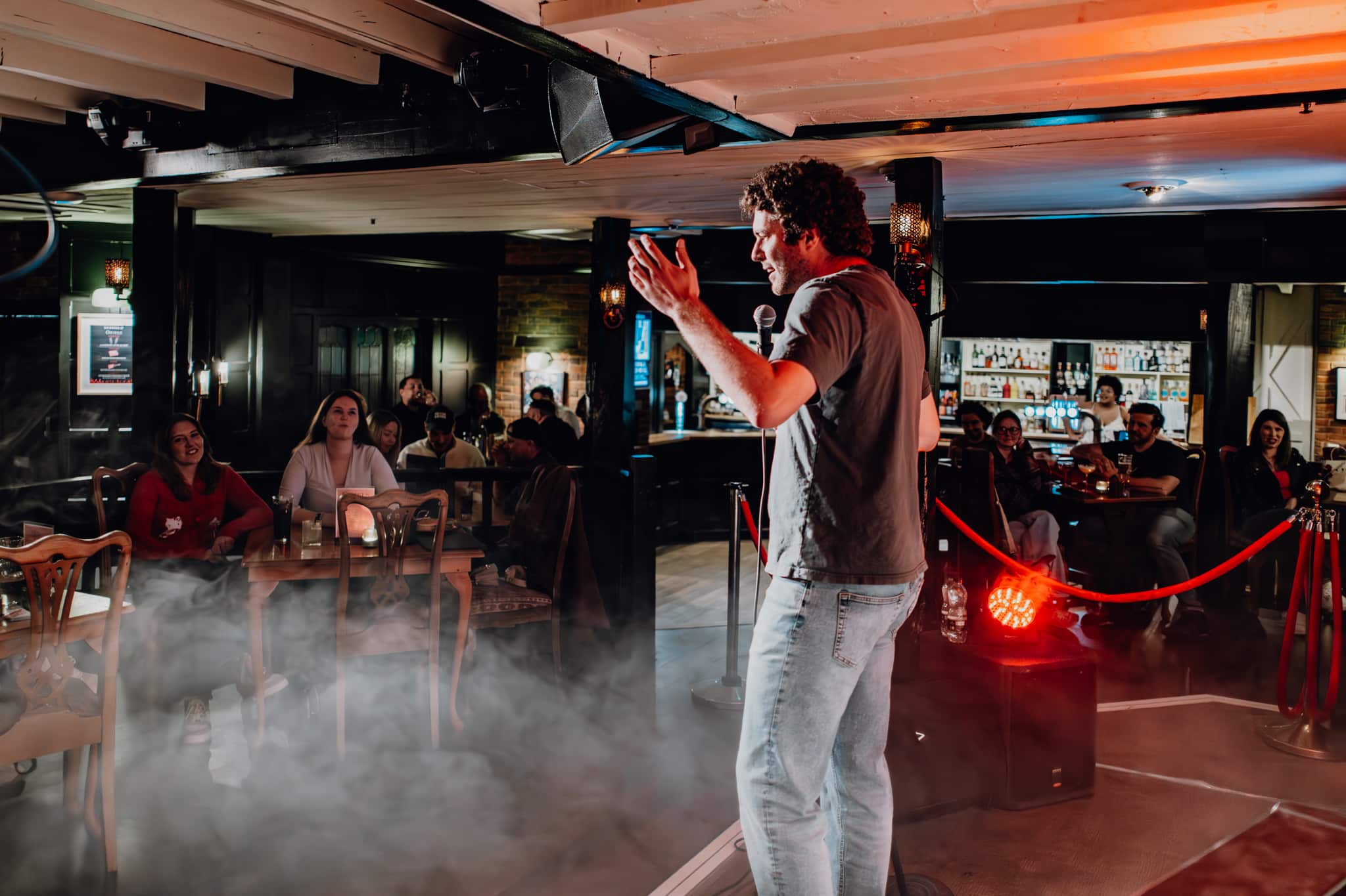 Comedian performing to the audience at Oriels Exeter