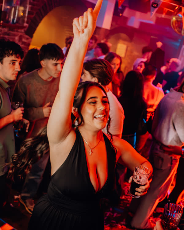 Guest dancing with her hand in the air at Oriels Exeter